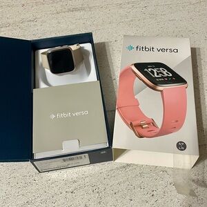 Fitbit Versa fitness tracker with chargers and bands